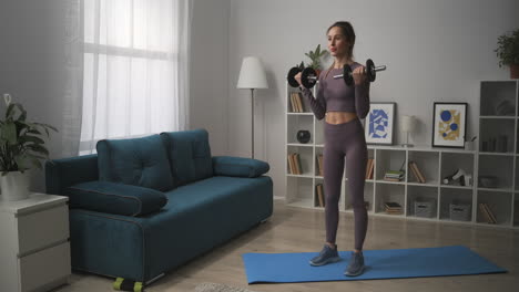 home-workout-with-dumbbells-for-good-shape-of-body-sporty-woman-is-training-apartment-fitness-and-wellness-healthy-lifestyle